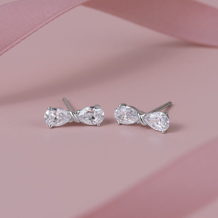 Ballerina: Sterling Silver Rhodium Plated CZ Pear Cut Infinity Bow Stud Earrings